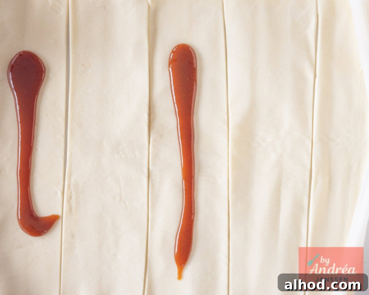 Puff pastry cut into strips with a thin line of curry sauce spread down the center of each strip.