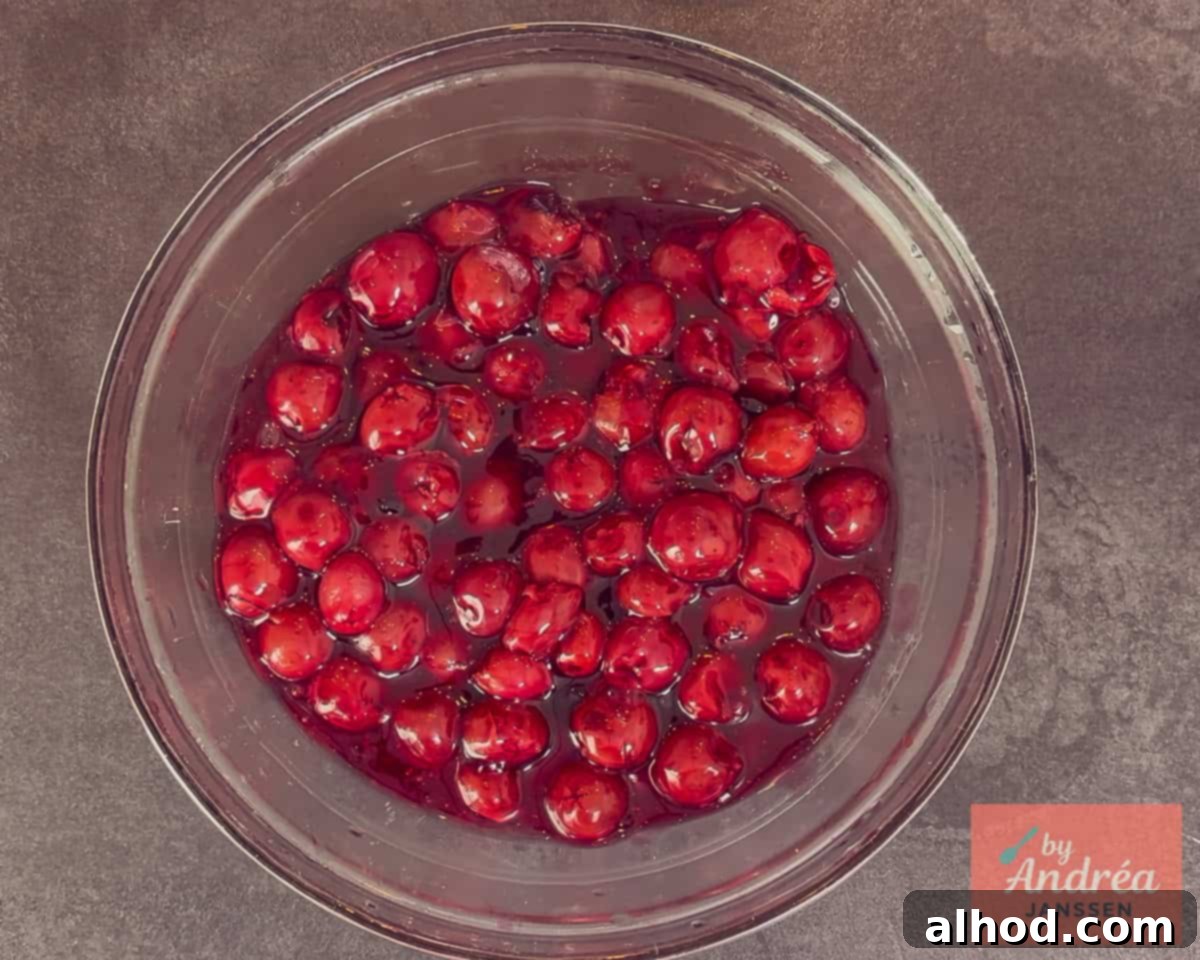 The finished cherry pie filling is in a black bowl, ready to cool completely before use.