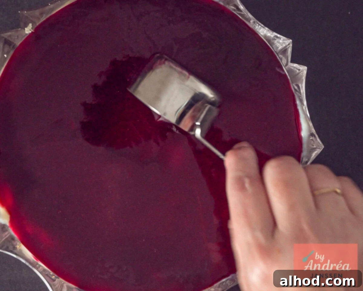 Red fruit jelly is poured over the trifle.