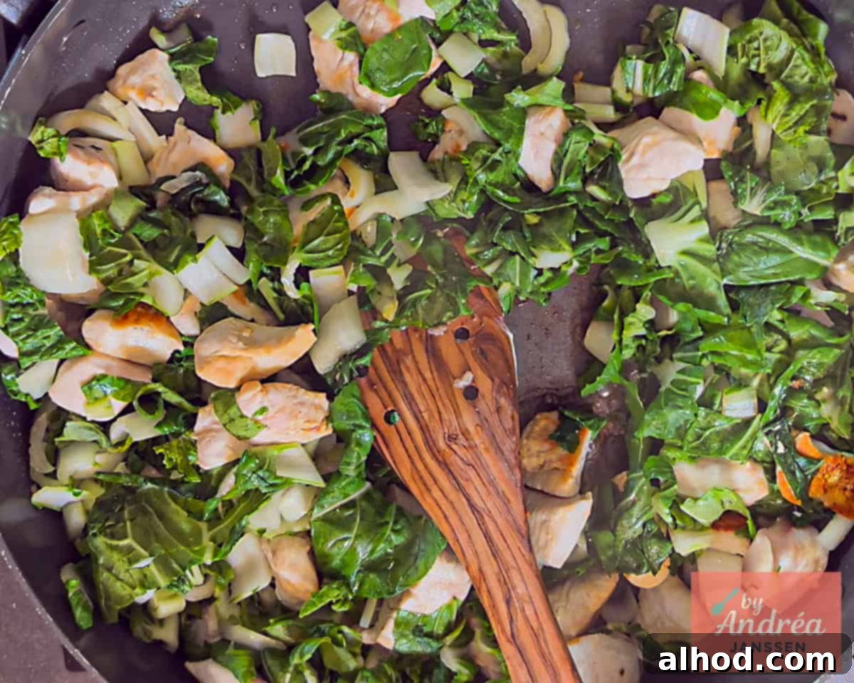 Quick Chicken Pad See Ew: 20-Minute Thai Noodle Perfection 5 Stir-frying chicken and bok choy in a wok for Chicken Pad See Ew