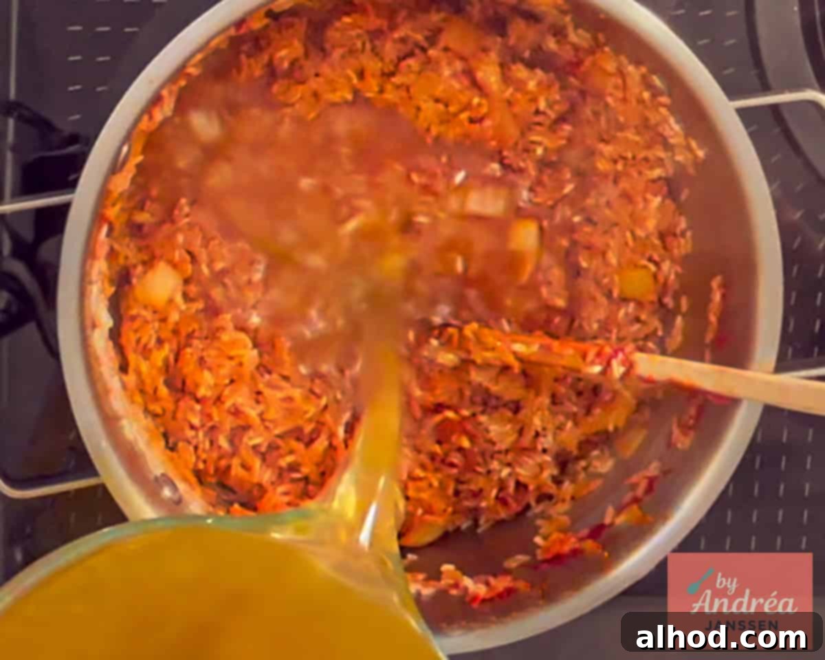 30-Minute Fiesta Rice 7 The broth is poured into the pan with the red rice.