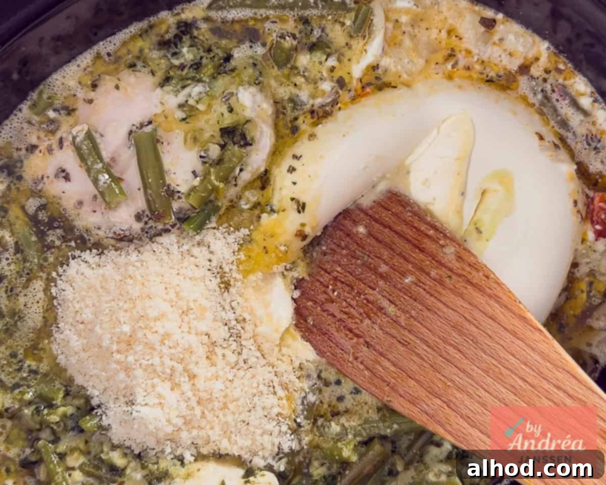 Slow Cooker Creamy Tuscan Pesto Chicken 7 Adding mascarpone and Parmesan cheese to the Tuscan chicken, creating a creamy and glossy sauce.