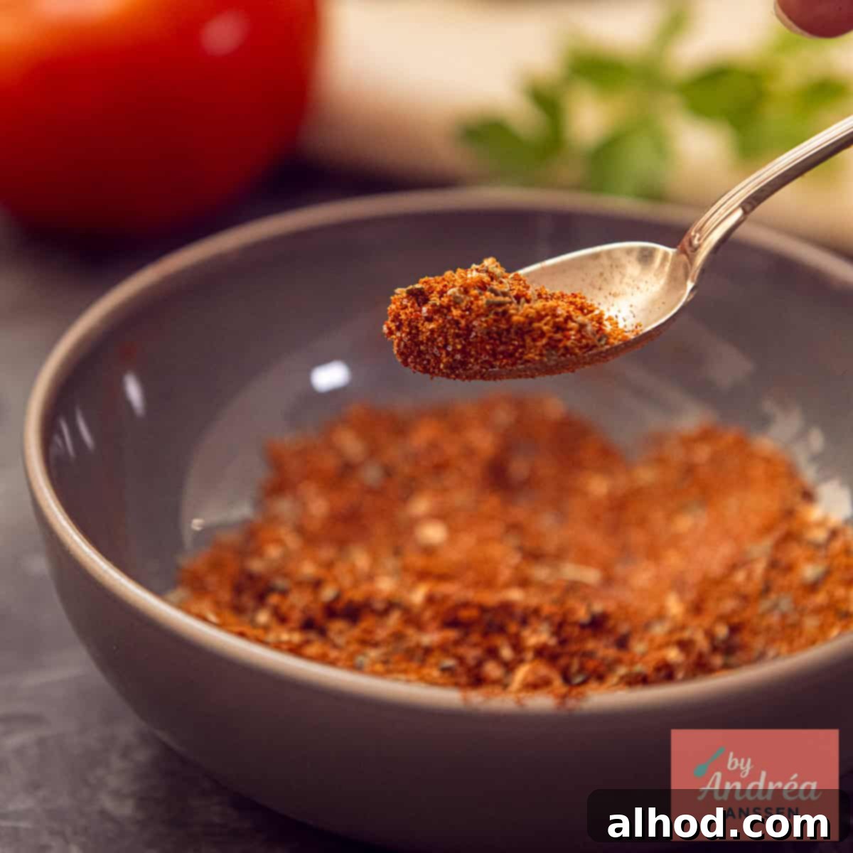 A close-up photo of a grey bowl containing homemade Mexican burrito spice mix.